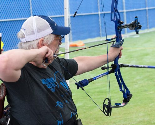 man in wheelchair shooting archery