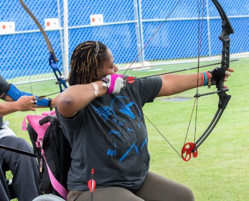 woman in wheelchair shooting archery