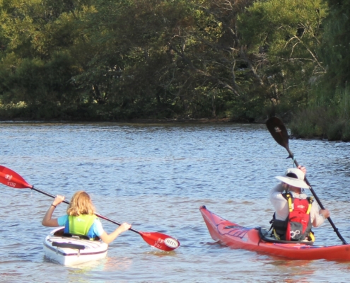 young girl with disability learning to kayak with Bridge 2 Sports coach