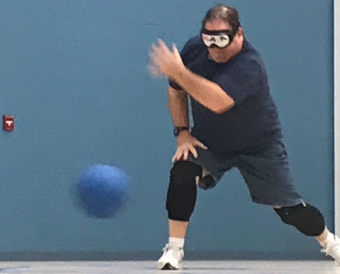 Goalball athlete standing and throwing the ball
